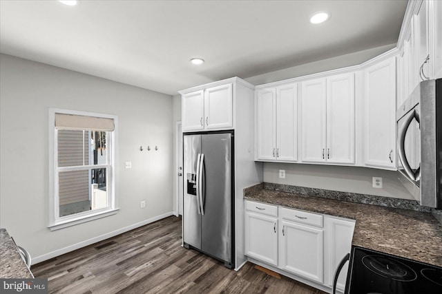 kitchen featuring stainless steel appliances, dark stone counters, dark wood-type flooring, and white cabinetry