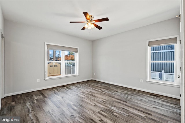 spare room featuring dark wood-type flooring and ceiling fan