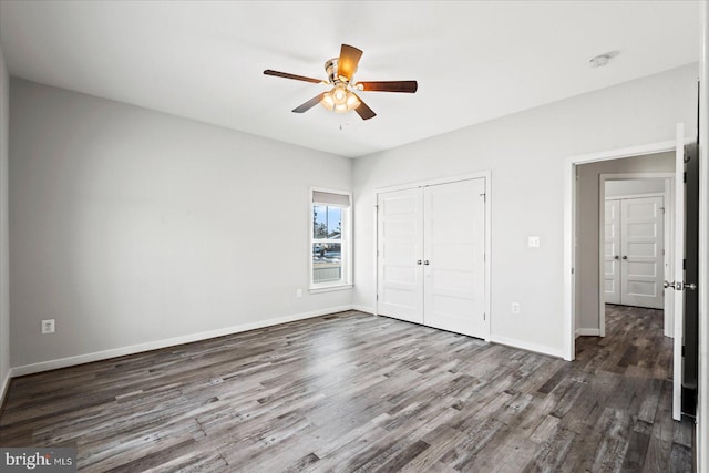 unfurnished bedroom featuring ceiling fan, a closet, and dark hardwood / wood-style floors