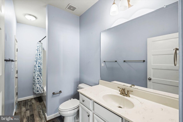 full bathroom featuring hardwood / wood-style floors, toilet, shower / bath combo, and vanity