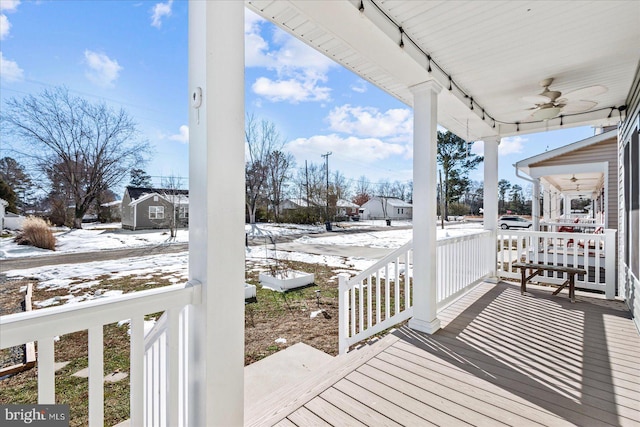 snow covered deck with a porch and ceiling fan