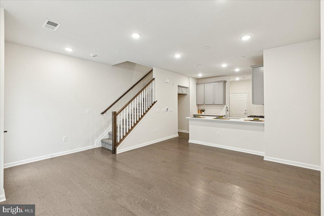 unfurnished living room with dark hardwood / wood-style floors and sink