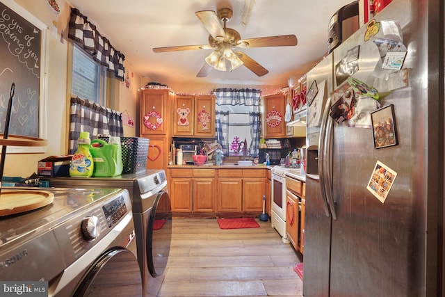 kitchen with washing machine and clothes dryer, sink, white range, stainless steel fridge, and light hardwood / wood-style floors