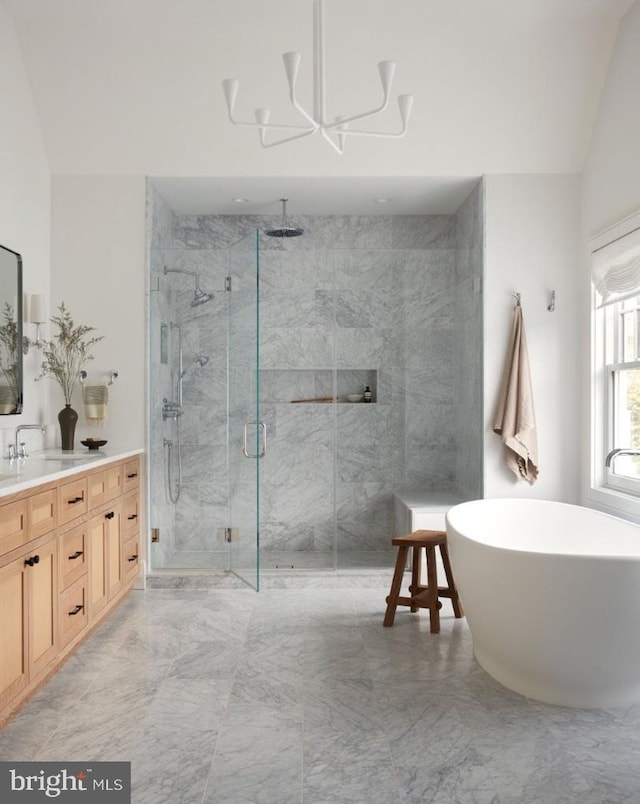 bathroom with lofted ceiling, shower with separate bathtub, a notable chandelier, and vanity