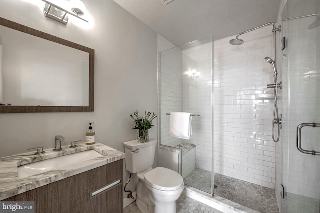 bathroom with vanity, toilet, and a shower with door