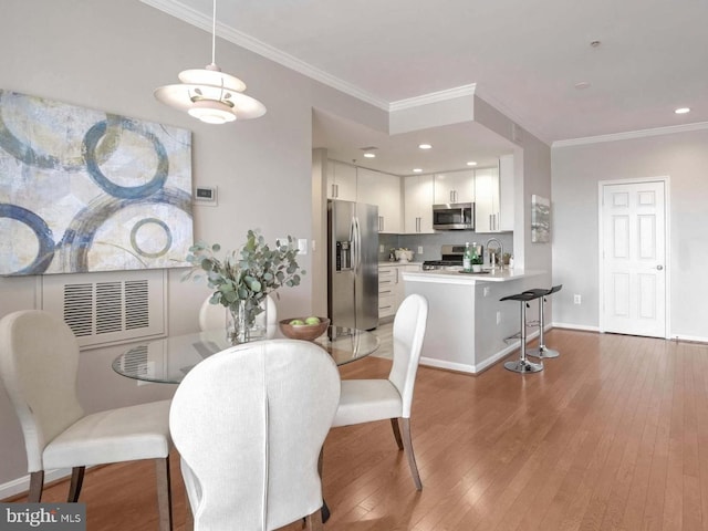 dining area with dark hardwood / wood-style flooring and crown molding