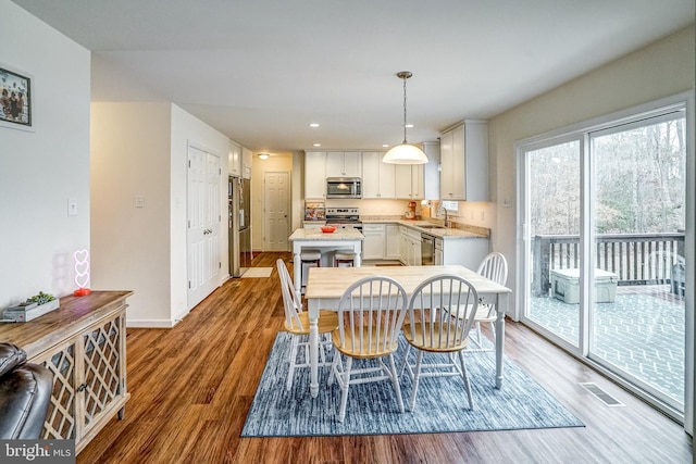 dining space with sink and light hardwood / wood-style floors