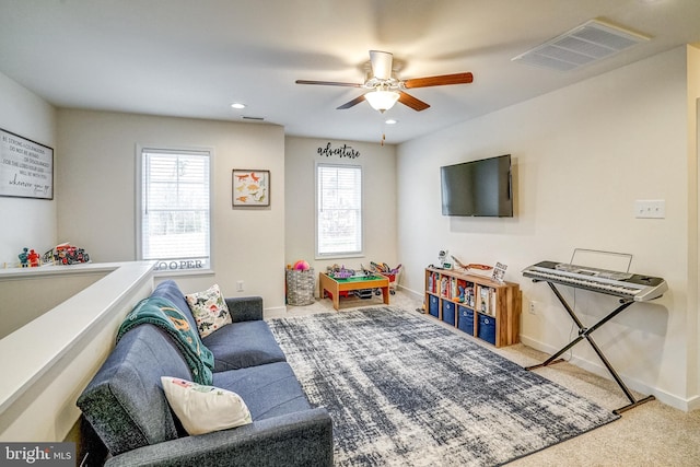 recreation room with ceiling fan, plenty of natural light, and carpet