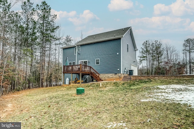 back of house featuring a garage, a lawn, and a deck