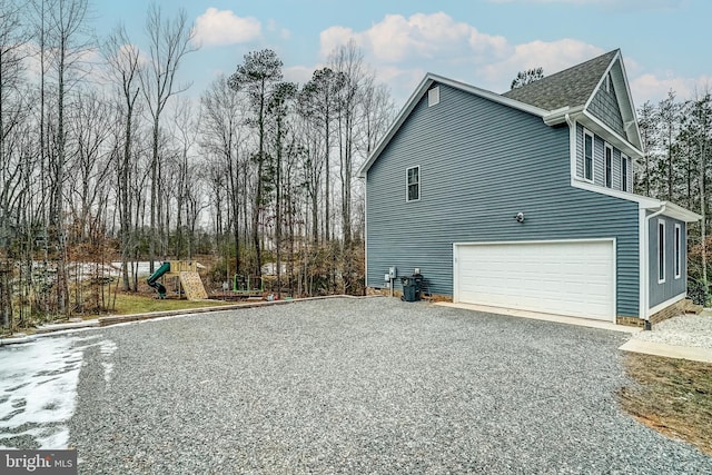 view of property exterior with a playground and a garage