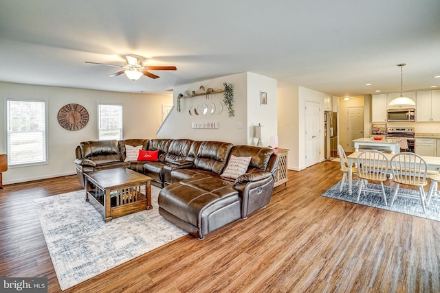 living room featuring ceiling fan and light wood-type flooring