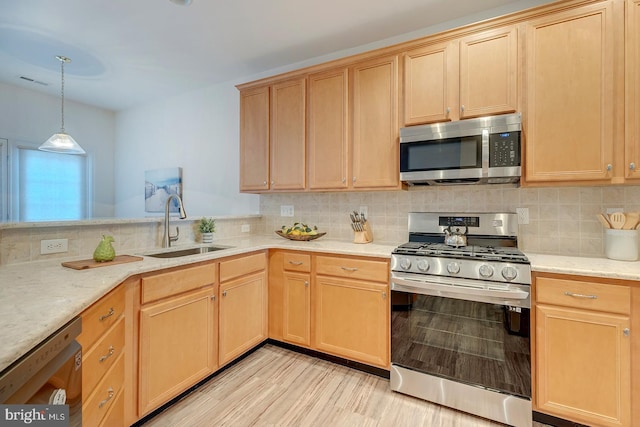 kitchen featuring decorative light fixtures, light brown cabinets, stainless steel appliances, sink, and backsplash