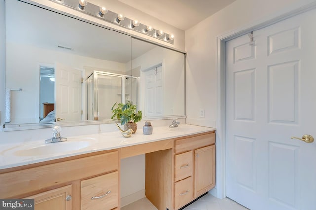 bathroom with an enclosed shower, vanity, and tile patterned flooring