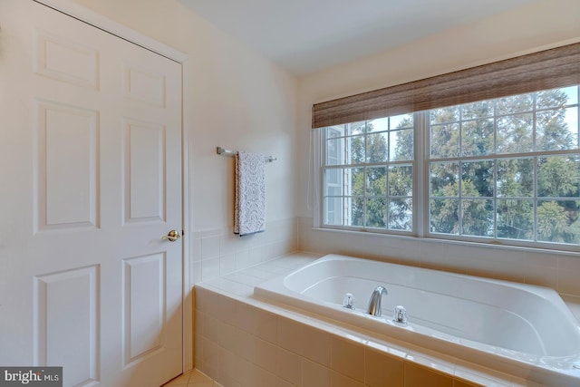 bathroom featuring tiled bath and tile patterned flooring