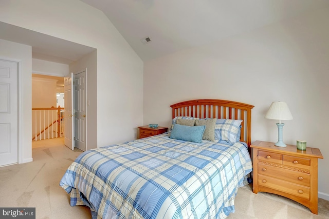 bedroom with light colored carpet and vaulted ceiling