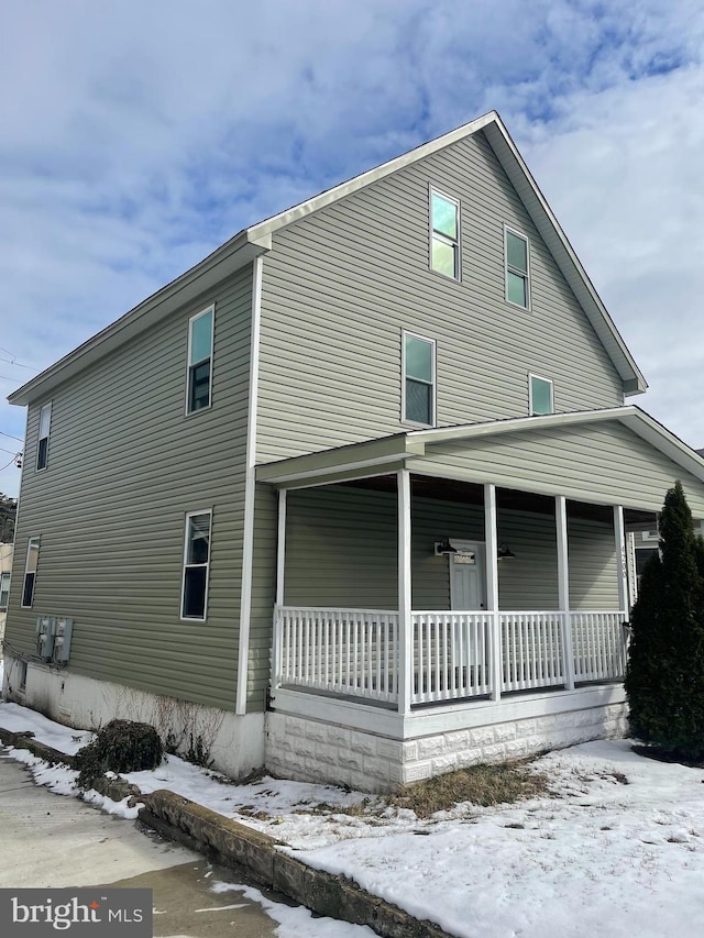 view of snowy exterior with a porch