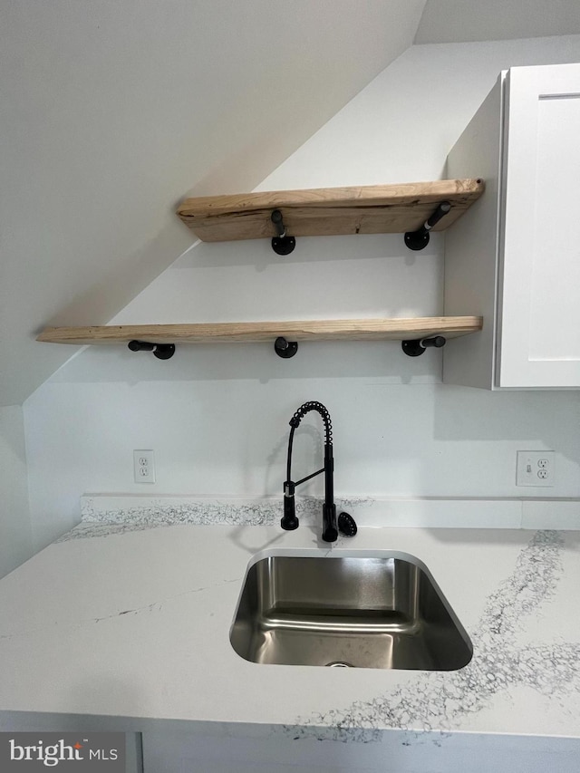 room details featuring white cabinetry and sink