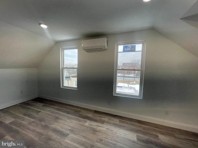 additional living space with wood-type flooring, a wall mounted AC, and lofted ceiling