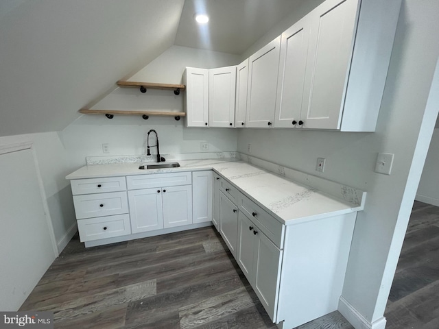 kitchen with vaulted ceiling, dark hardwood / wood-style floors, white cabinetry, and sink