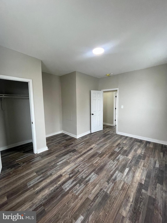 unfurnished bedroom featuring dark hardwood / wood-style flooring and a closet