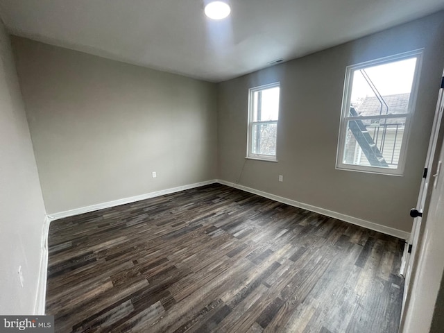 unfurnished room with dark hardwood / wood-style flooring