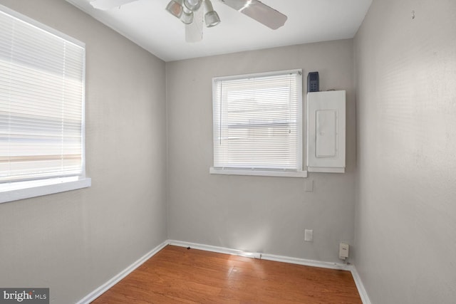 empty room with hardwood / wood-style floors and electric panel