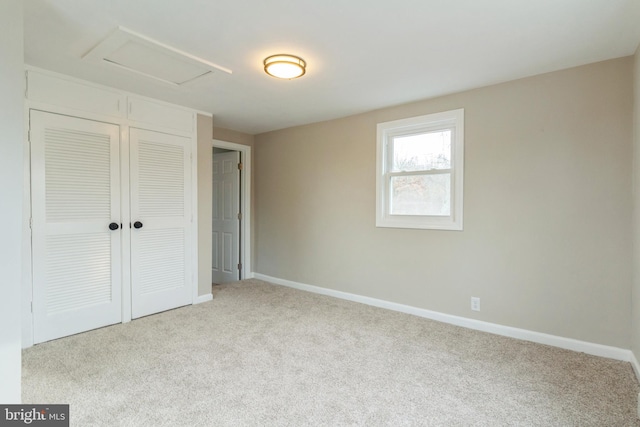 unfurnished bedroom featuring light colored carpet and a closet