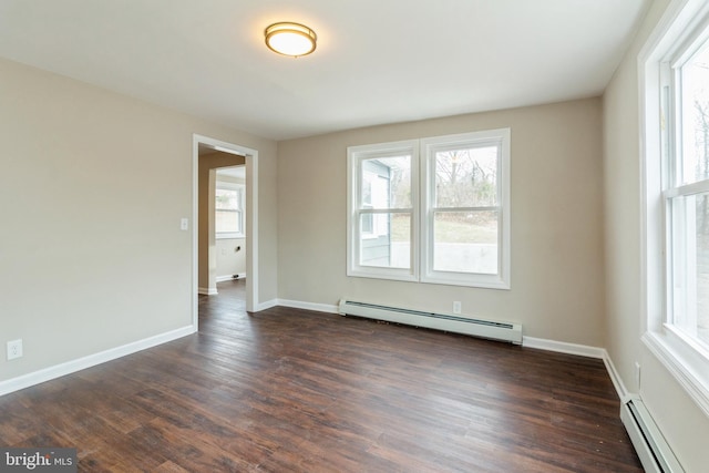 unfurnished room with baseboard heating, dark hardwood / wood-style flooring, and a healthy amount of sunlight