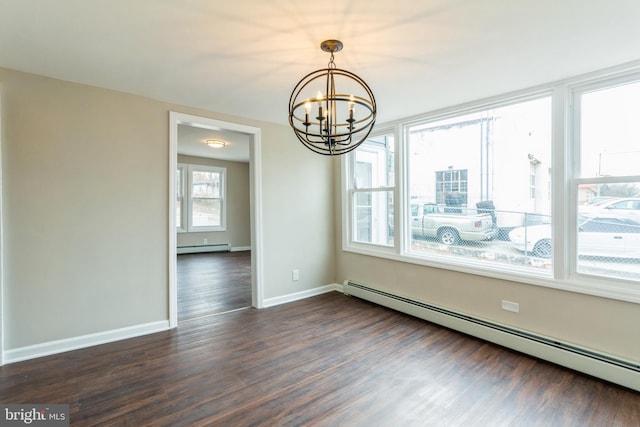 spare room featuring an inviting chandelier, baseboard heating, and dark wood-type flooring