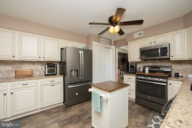 kitchen featuring stainless steel appliances, ceiling fan, wooden counters, decorative backsplash, and dark wood-type flooring