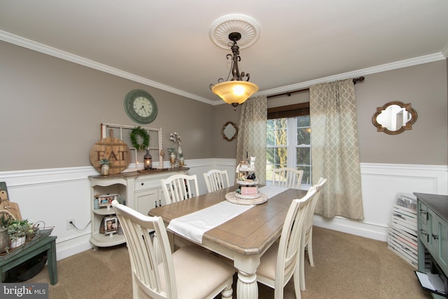 carpeted dining room with ornamental molding