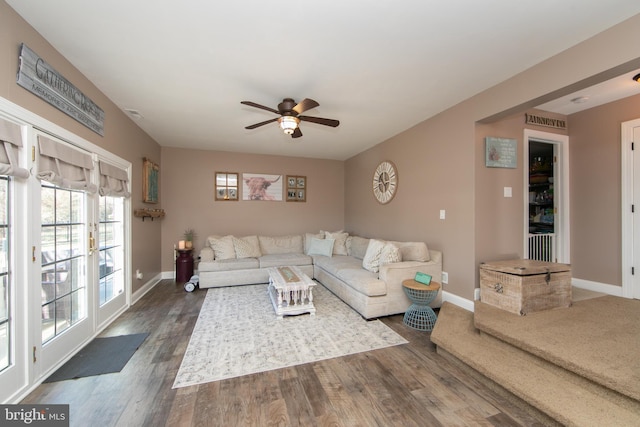 living room with dark hardwood / wood-style flooring and ceiling fan