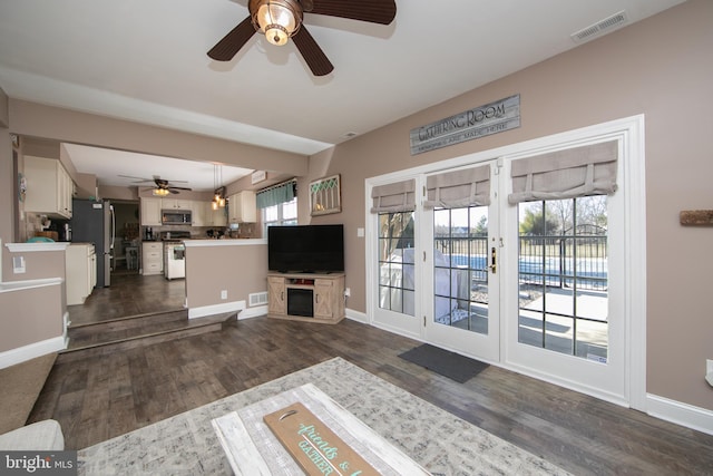 living room with ceiling fan and dark hardwood / wood-style floors