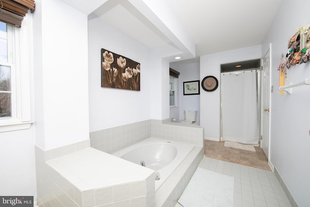 bathroom with tile patterned flooring and a relaxing tiled tub