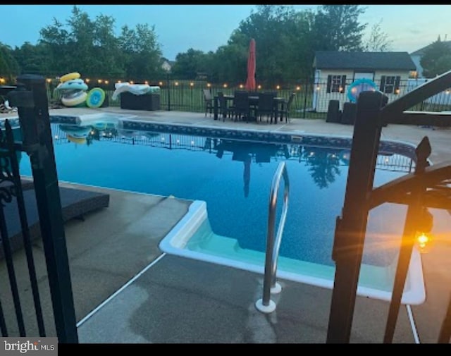 pool at dusk with a patio