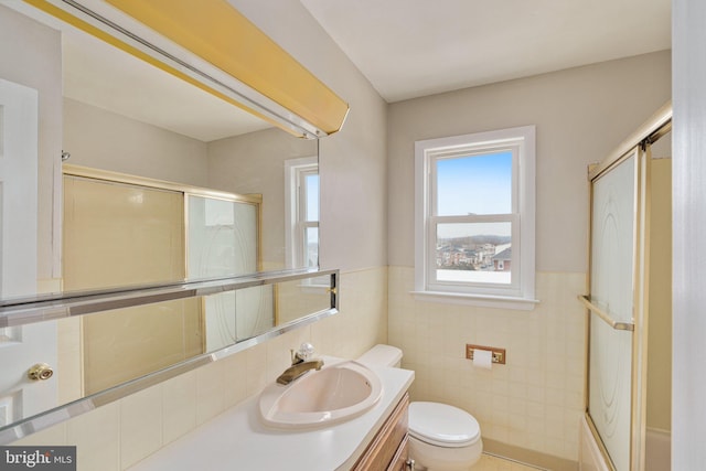 full bathroom with toilet, vanity, tile walls, and combined bath / shower with glass door