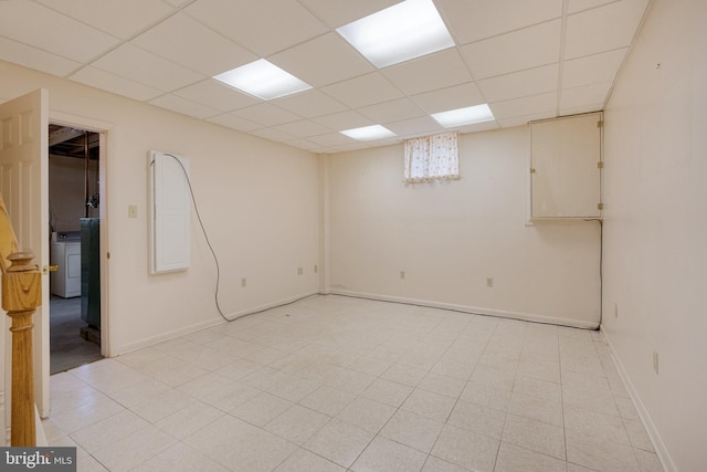 basement with a paneled ceiling and washer / dryer