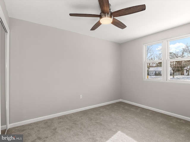 carpeted spare room featuring ceiling fan