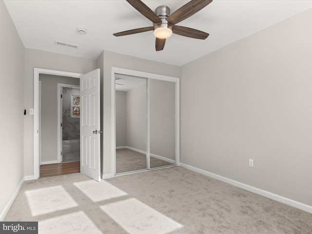 unfurnished bedroom featuring ceiling fan, a closet, and light carpet