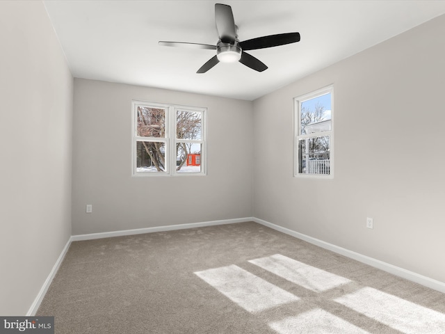 carpeted spare room with ceiling fan