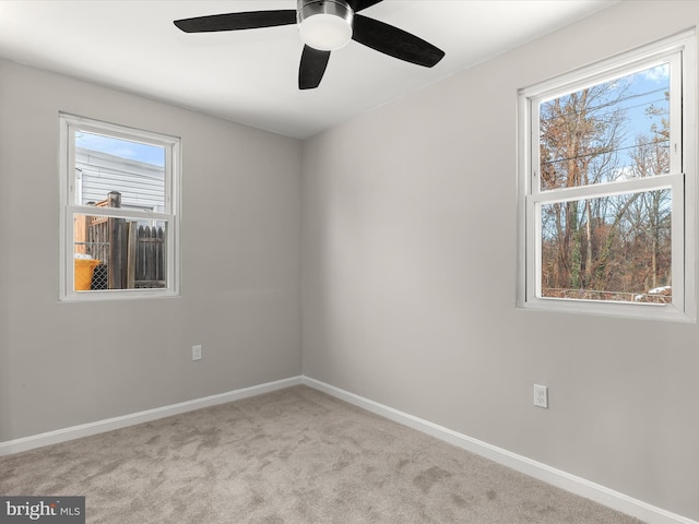 empty room featuring light colored carpet and ceiling fan