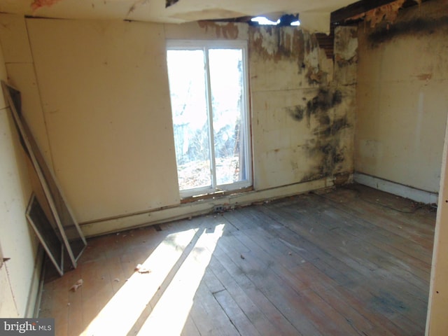 unfurnished room featuring hardwood / wood-style flooring and a healthy amount of sunlight