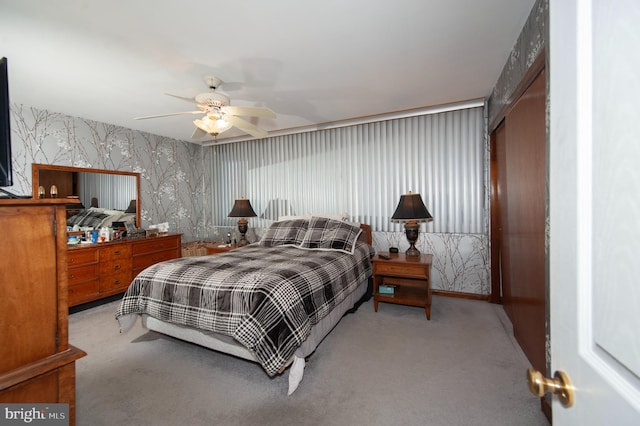 carpeted bedroom with ceiling fan and a closet