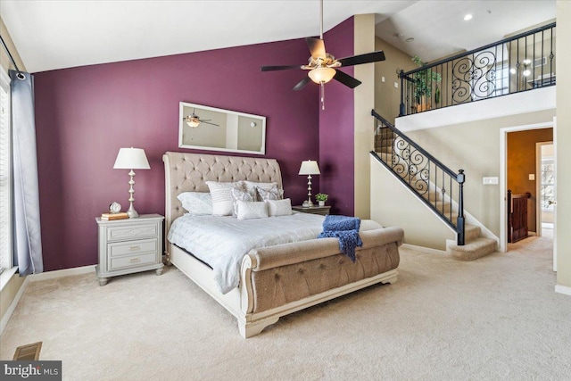 bedroom with multiple windows, light colored carpet, high vaulted ceiling, and ceiling fan