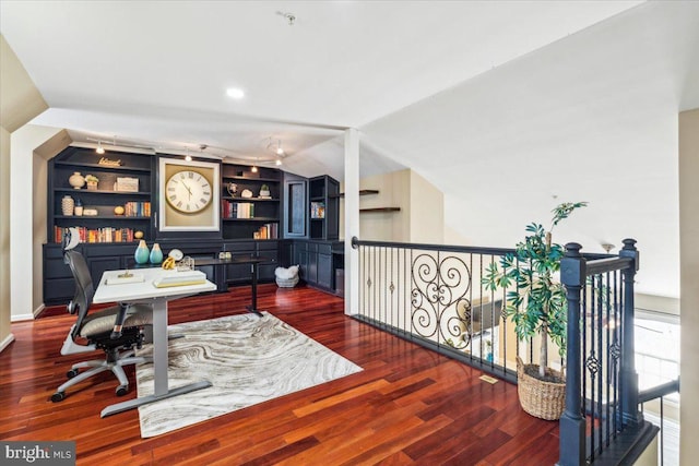 office space featuring built in shelves, vaulted ceiling, and hardwood / wood-style floors