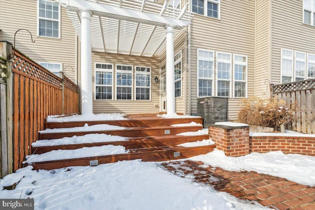 snow covered property entrance featuring a pergola