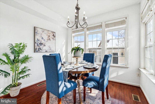 dining room featuring an inviting chandelier and dark wood-type flooring