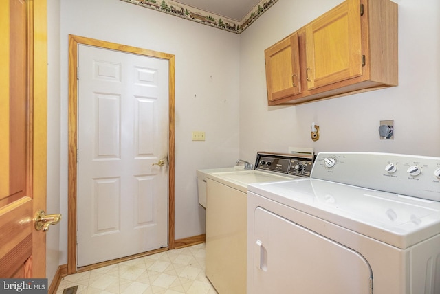 laundry area featuring light floors, cabinet space, baseboards, and separate washer and dryer