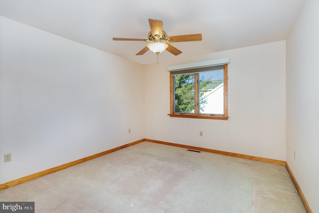 unfurnished room with light carpet, visible vents, baseboards, and ceiling fan