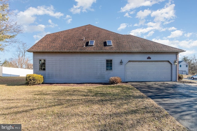 view of home's exterior featuring aphalt driveway, a lawn, a shingled roof, and fence